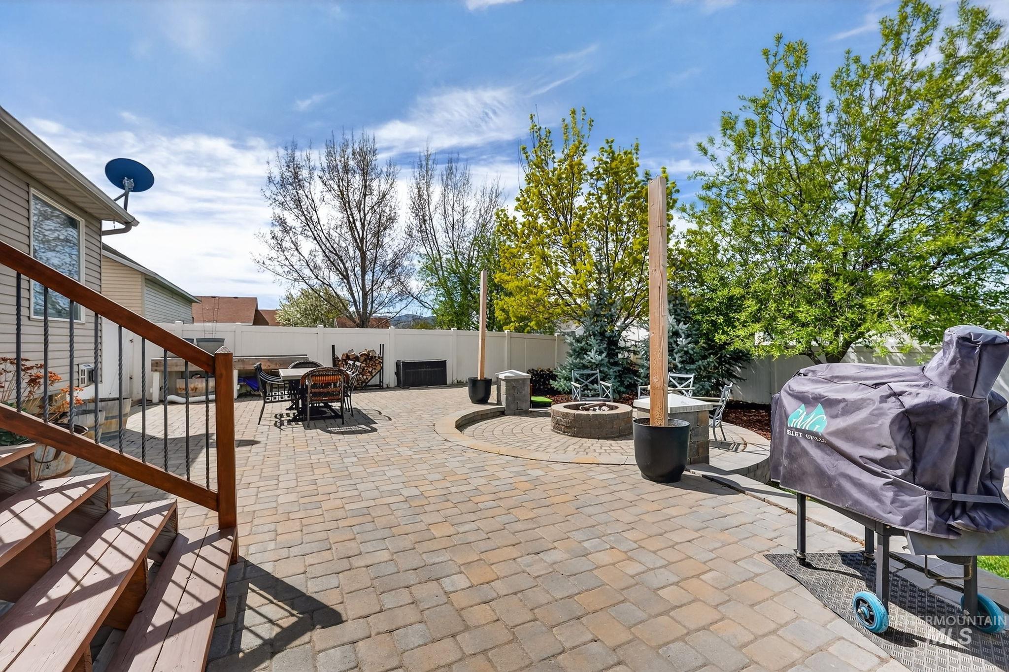 880 Redman Street Chubbuck, ID 83202 - Photo 27 of 39 Fenced backyard featuring a patio, an outdoor fire pit, outdoor dining space, and grilling area