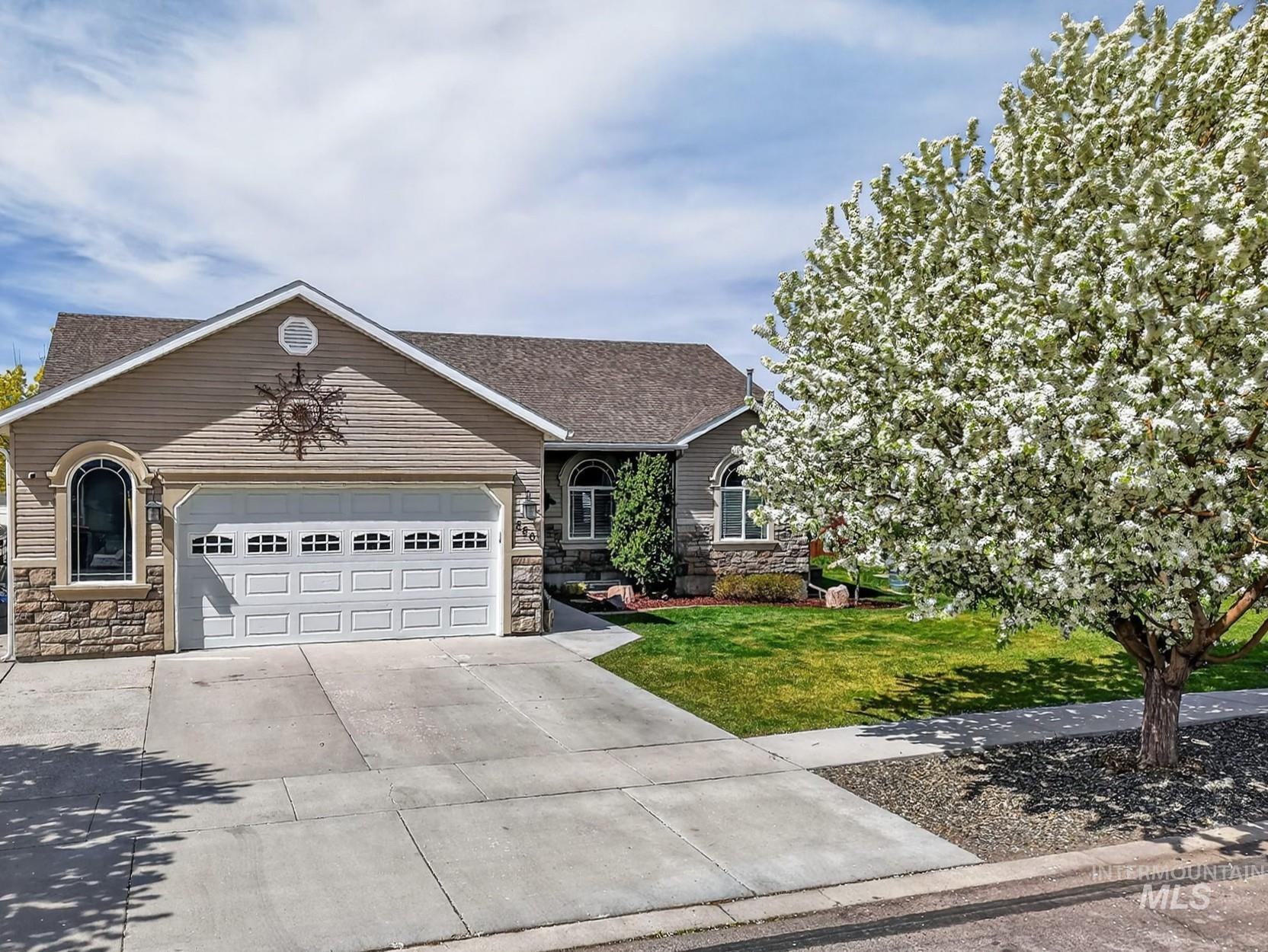 880 Redman Street Chubbuck, ID 83202 - Photo 4 of 39 Single story home featuring stone siding, an attached garage, driveway, a front lawn, and roof with shingles
