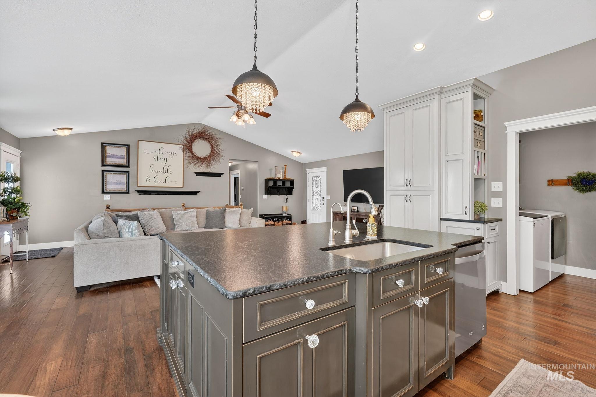 880 Redman Street Chubbuck, ID 83202 - Photo 39 of 39 Dual tone kitchen featuring open floor plan, two tone color scheme, a center island with sink, hanging light fixtures, and glass fronted cabinets