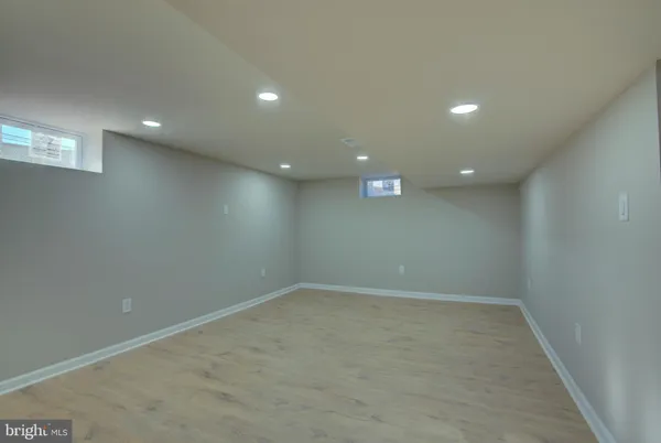 an empty room with a wooden floor and windows