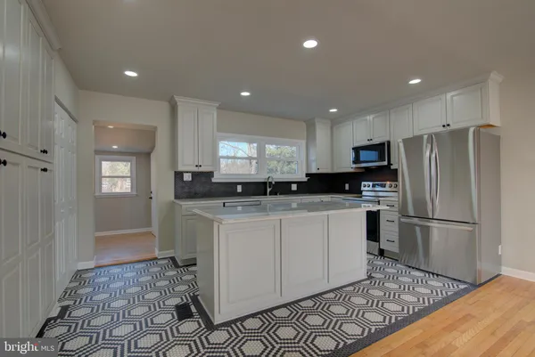 a kitchen with a refrigerator and a stove top oven