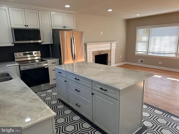 a kitchen with granite countertop a refrigerator stove and microwave