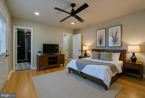 a spacious bedroom with a bed and a flat screen tv