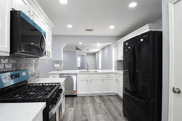 a kitchen with stainless steel appliances granite countertop a stove a sink and a microwave