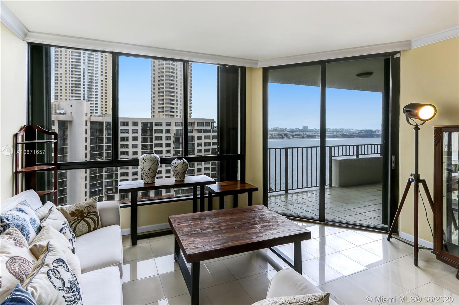 520 Brickell Key Drive, Unit A1702 Miami, FL 33131 - Photo 1 of 13 a living room with furniture next to a window
