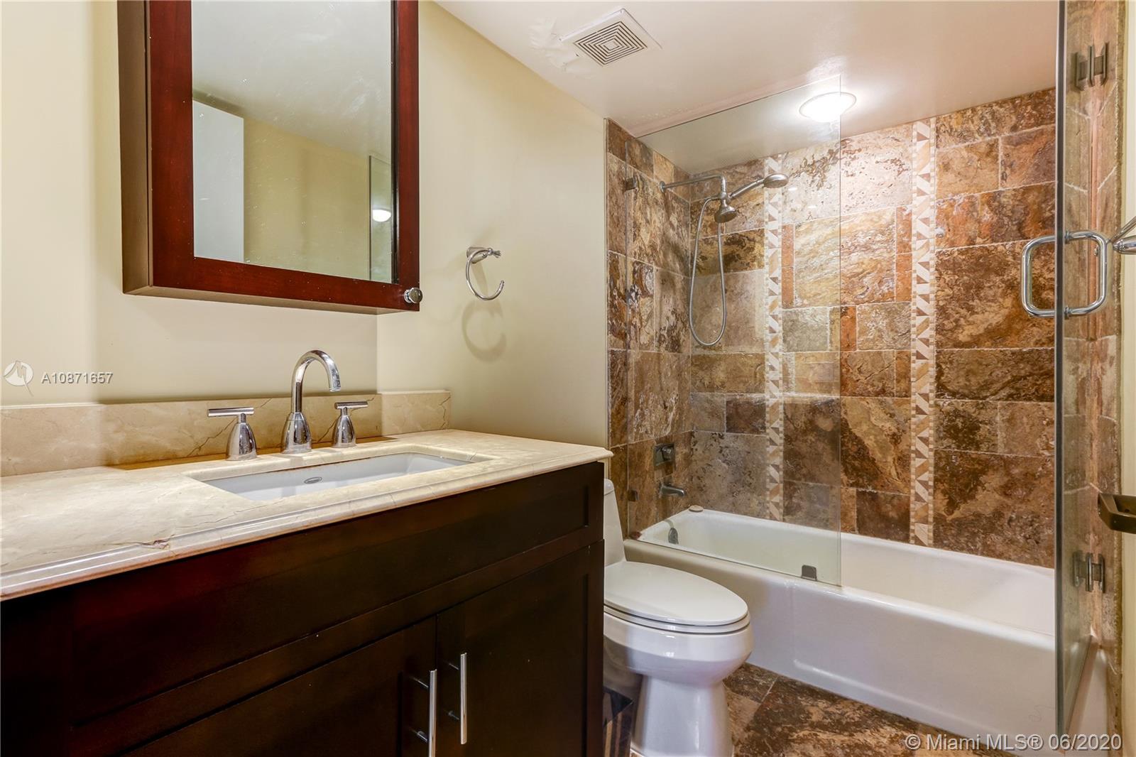 520 Brickell Key Drive, Unit A1702 Miami, FL 33131 - Photo 11 of 13 a bathroom with a granite countertop sink toilet and shower
