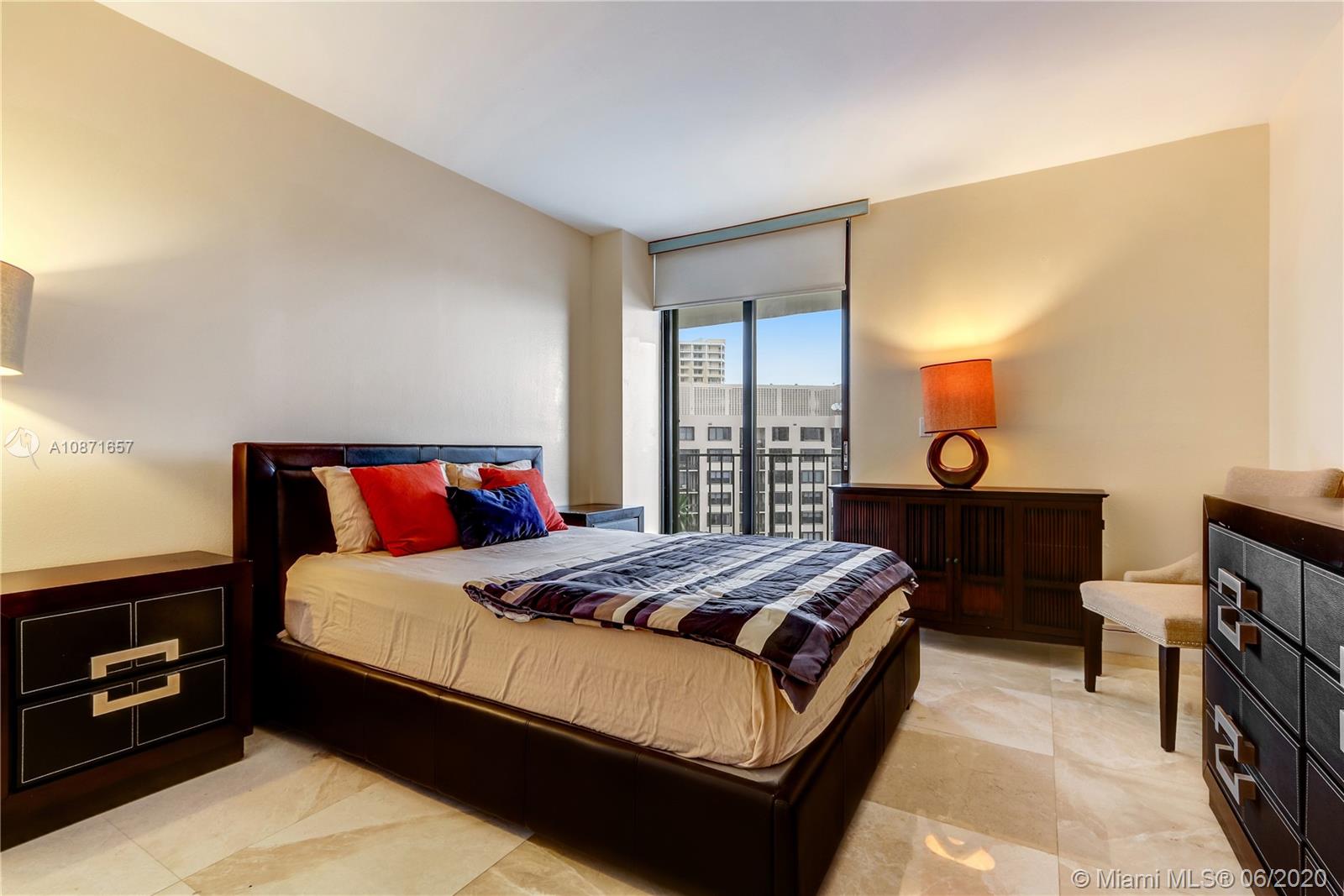 520 Brickell Key Drive, Unit A1702 Miami, FL 33131 - Photo 10 of 13 a bedroom with a bed and a lamp on dresser