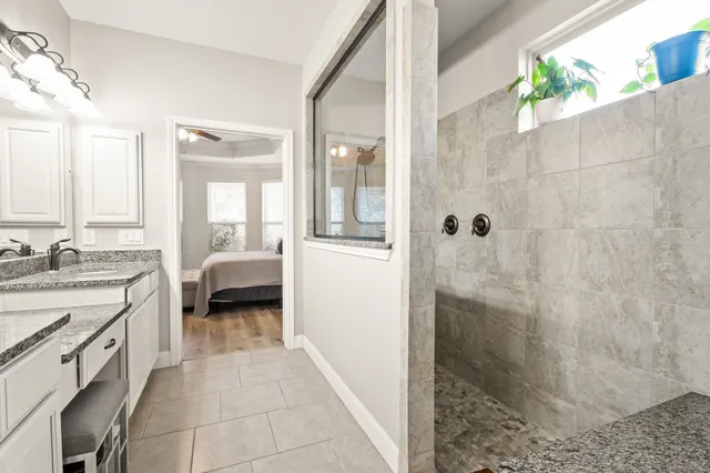 a en suite bathroom with a double vanity sink and a mirror