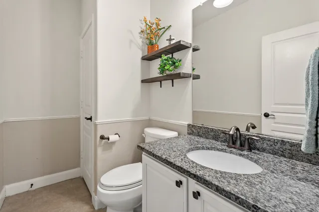 a bathroom with a granite countertop sink a toilet and a mirror