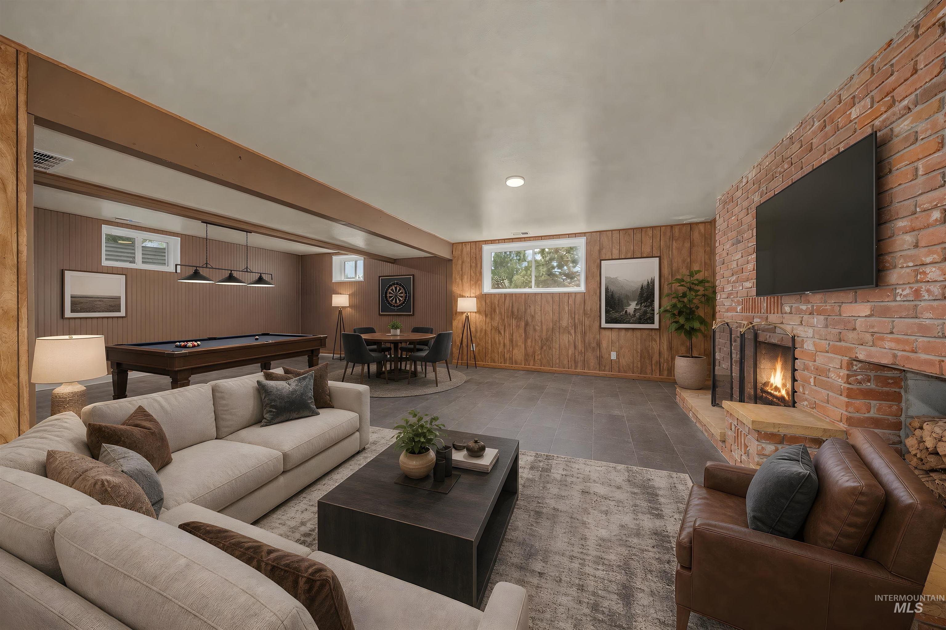 748 Pringle Road Weiser, ID 83672 - Photo 19 of 47 Spacious recreation room featuring a brick fireplace, wood-finish paneling, and tile flooring