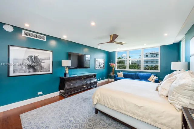 a large bedroom with a bed and a flat screen tv