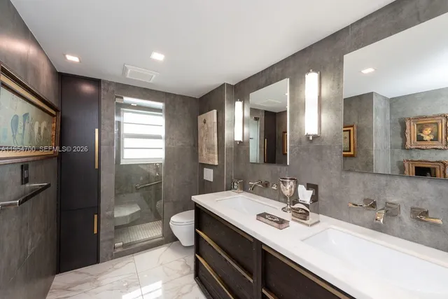 a bathroom with a double vanity sink a toilet and mirror