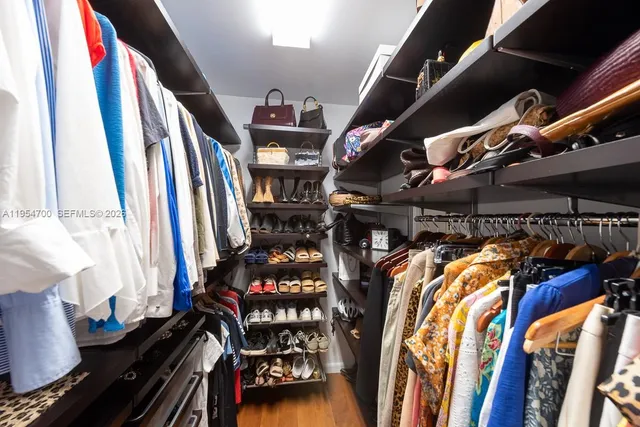 a view of walk in closet with clothes and shoes