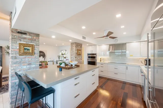 a kitchen with white cabinets stove and refrigerator