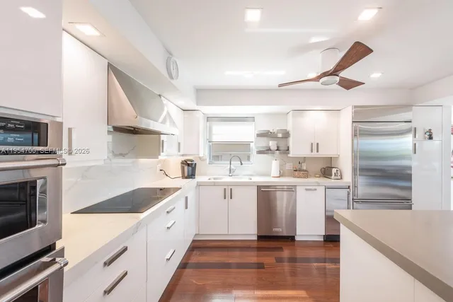 a large white kitchen with a stove top oven a sink dishwasher and a refrigerator