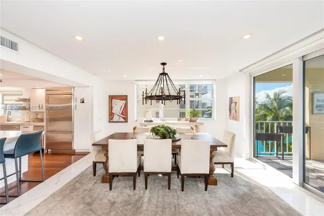a dining room with furniture a chandelier and wooden floor