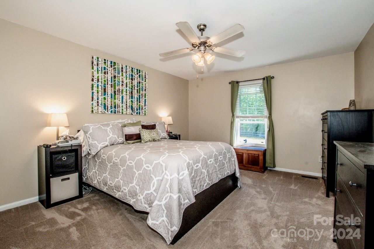 3510 Mack Ballard Road Maiden, NC 28650 - Photo 15 of 26 a bedroom with a bed and a chandelier
