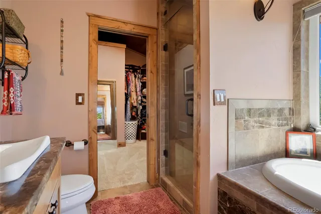 a en suite bathroom with a granite countertop tub and a fireplace