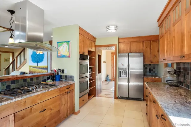 a kitchen with stainless steel appliances granite countertop a refrigerator a stove and a sink