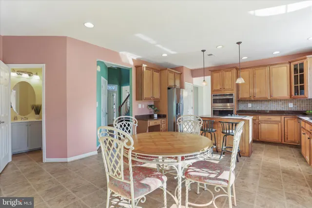 a dining room with furniture a large window and stainless steel appliances