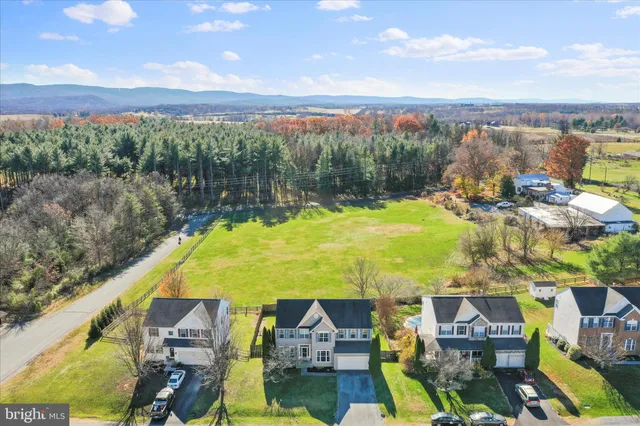 an aerial view of residential houses with outdoor space and ocean view