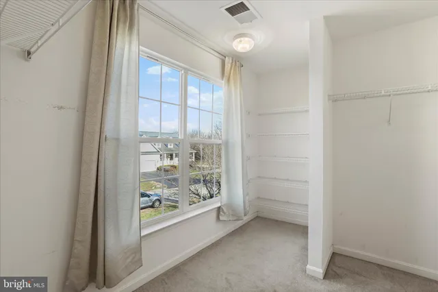 an empty room with closet and windows