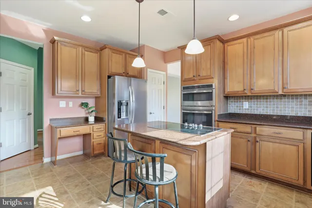 a kitchen with stainless steel appliances granite countertop a stove a sink refrigerator and cabinets