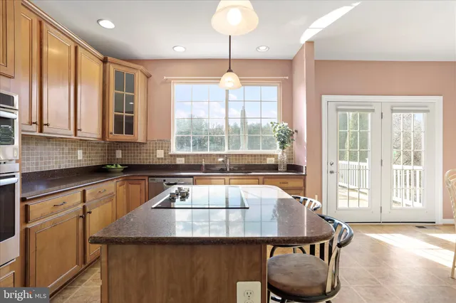 a kitchen with a table chairs and windows