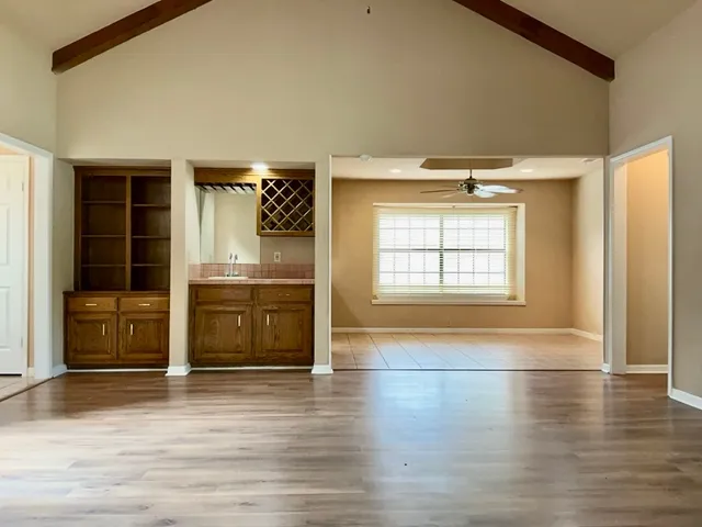 a living room with stainless steel appliances wooden floor and a fireplace