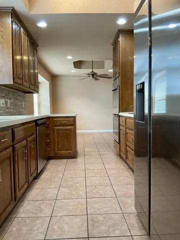 a kitchen with a sink refrigerator and cabinets