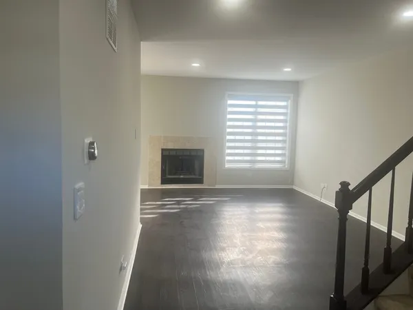 a view of empty room with fireplace and wooden floor