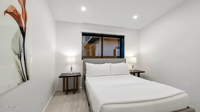 a bedroom with a bed and a painting on the wall