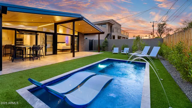 a view of swimming pool with lawn chairs and a yard