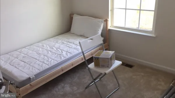 a bed sitting in a bedroom next to a window
