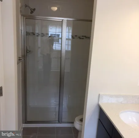 a bathroom with a granite countertop shower and a sink