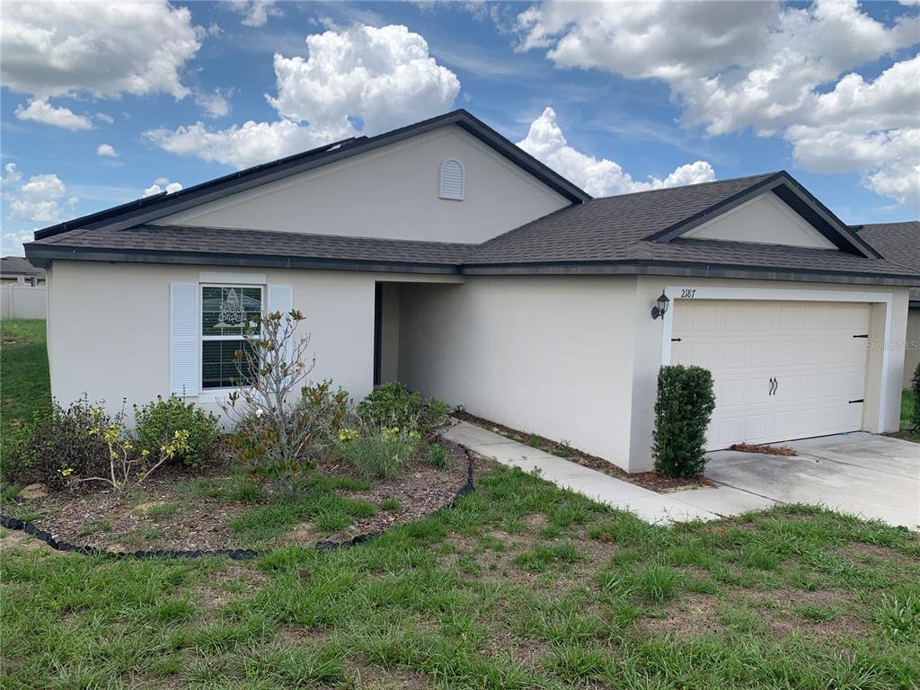 2187 Mandarin Loop Dundee, FL 33838 - Photo 3 of 11 a front view of a house with garden