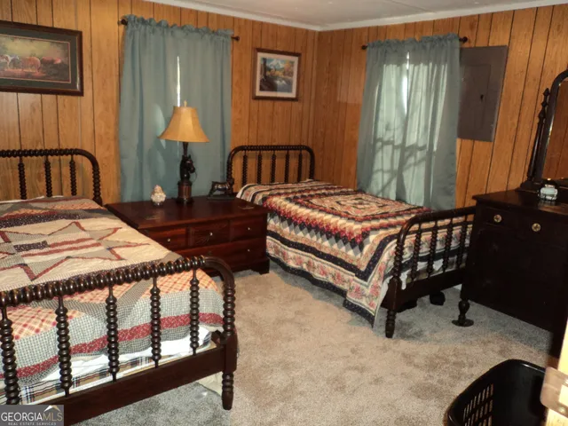 a bedroom with a bed chair and a lamp on table