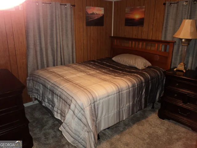 a bedroom with a bed and teddy bear on bed