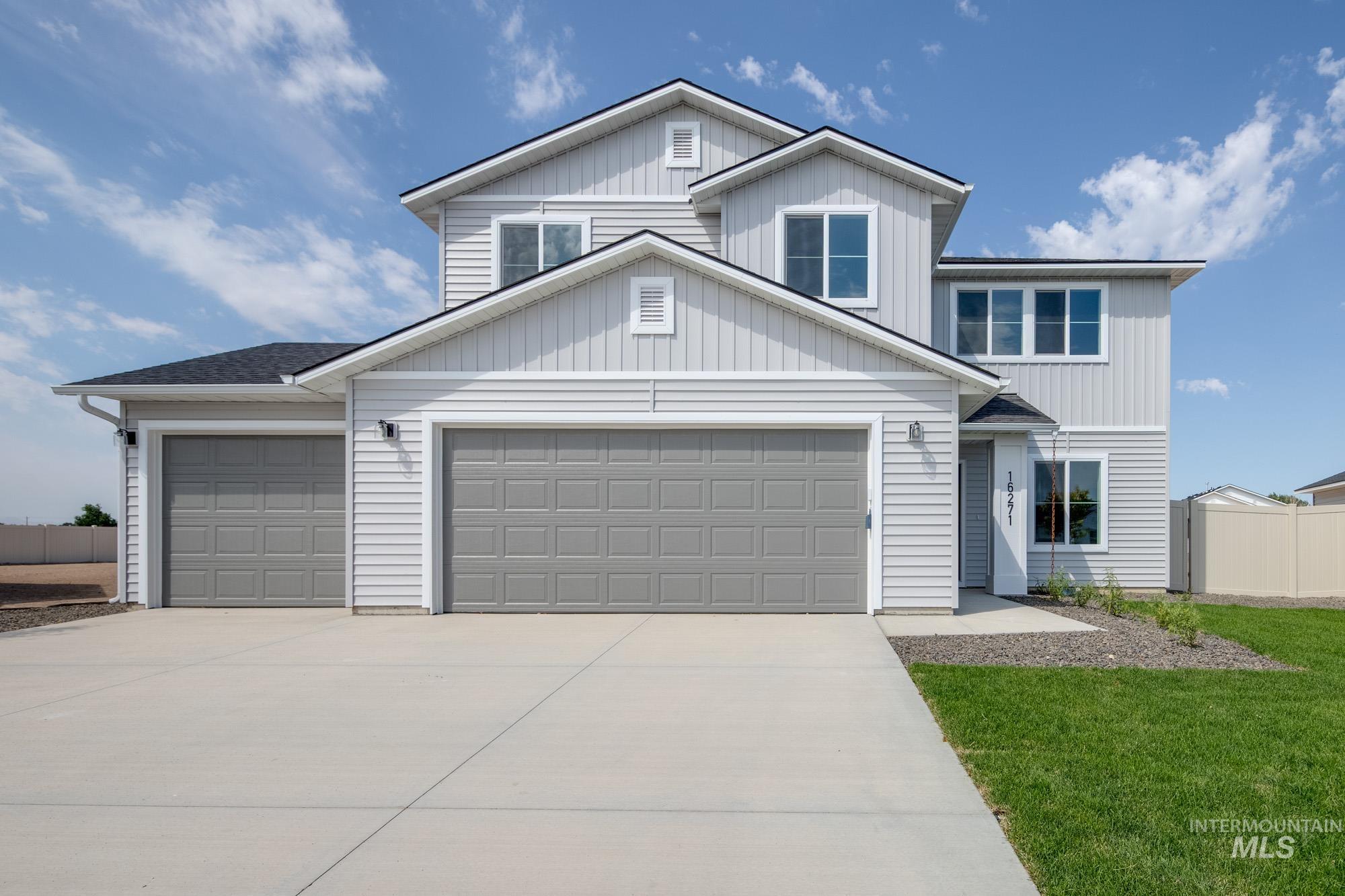 Traditional-style house with concrete driveway, a garage, and board and batten siding