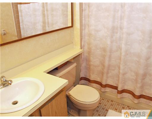 5605 Hana Road Edison, NJ 08817 - Photo 11 of 23 a bathroom with a sink toilet and mirror