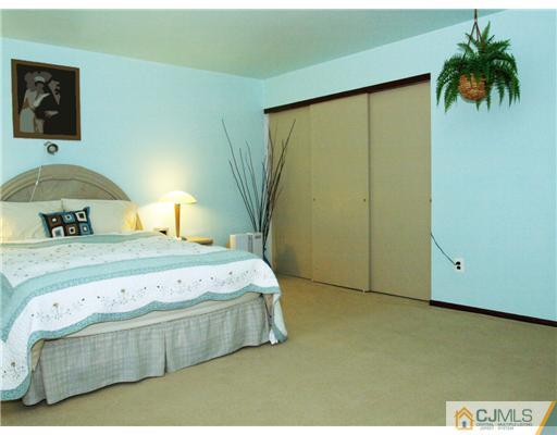 5605 Hana Road Edison, NJ 08817 - Photo 15 of 23 a bedroom with a bed and a dresser