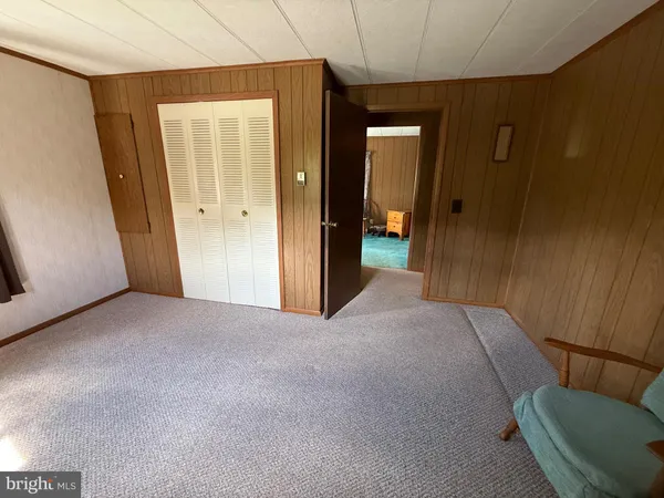 an empty room with windows closet and chandelier fan