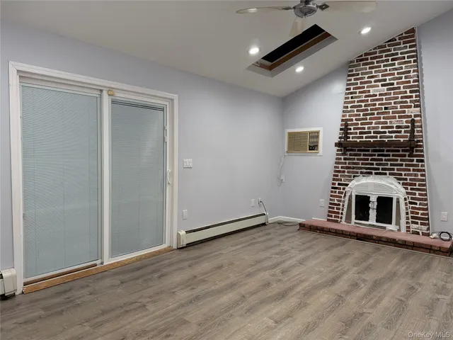 an empty room with wooden floor and fireplace