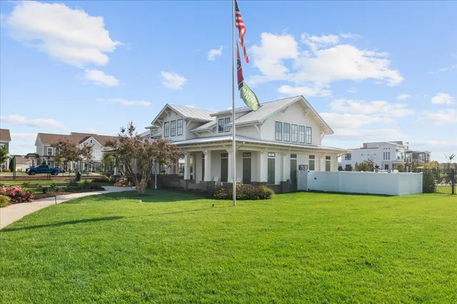 a view of a house with a big yard and large trees