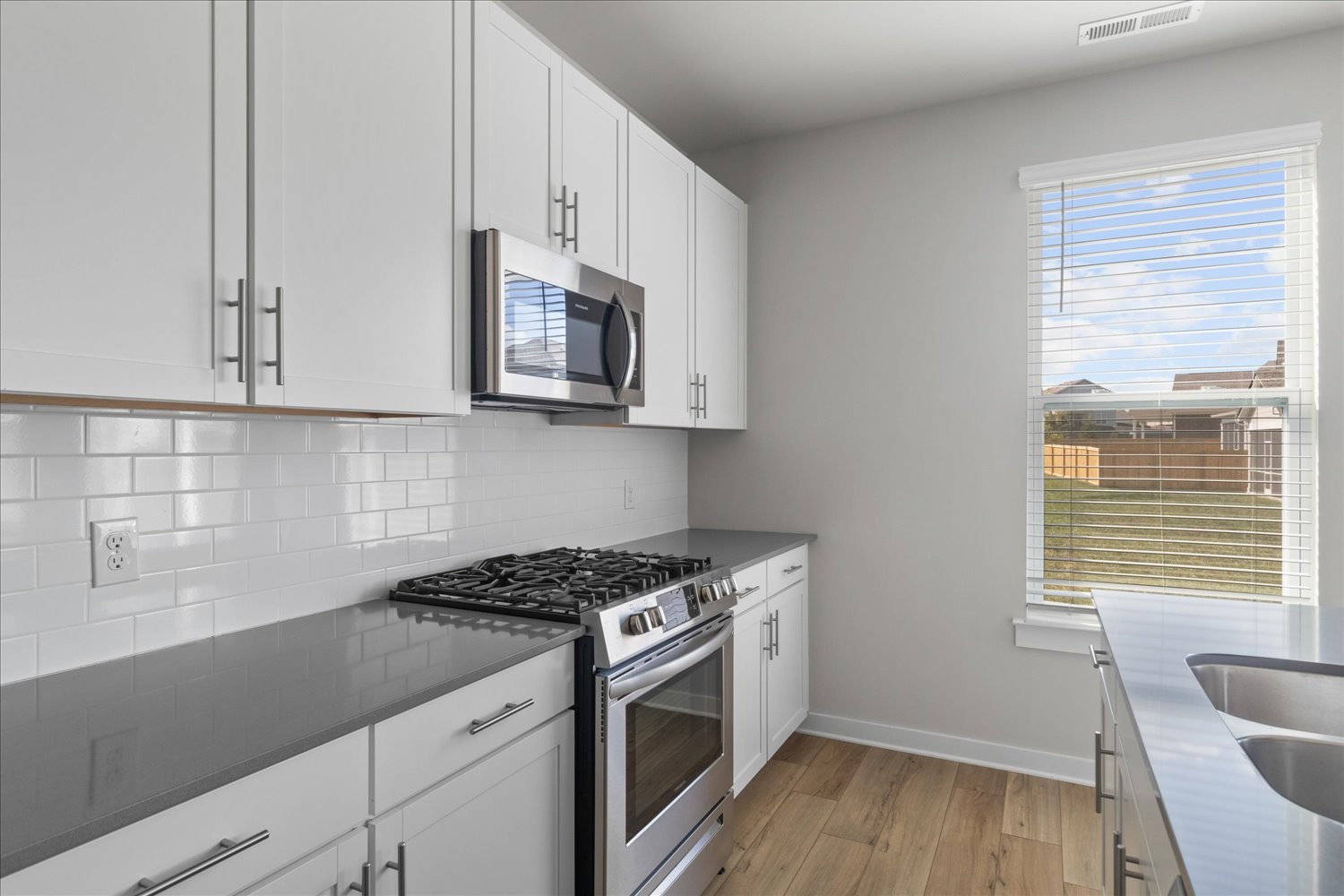 910 Sassafras Ct Spring Hill Spring Hill, TN 37174 - Photo 10 of 20 a kitchen with stainless steel appliances white cabinets a stove a microwave and a window