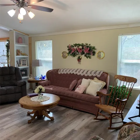 a living room with furniture flowers and a window