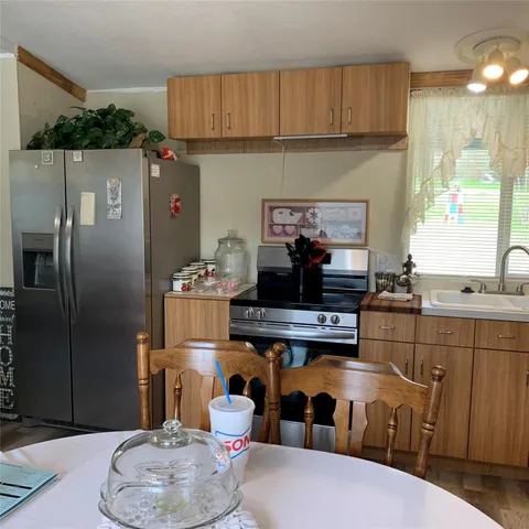 a kitchen with a table chairs stove and refrigerator