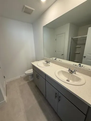 a bathroom with a double vanity sink and a mirror