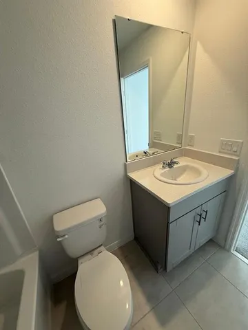 a bathroom with a sink vanity mirror and toilet