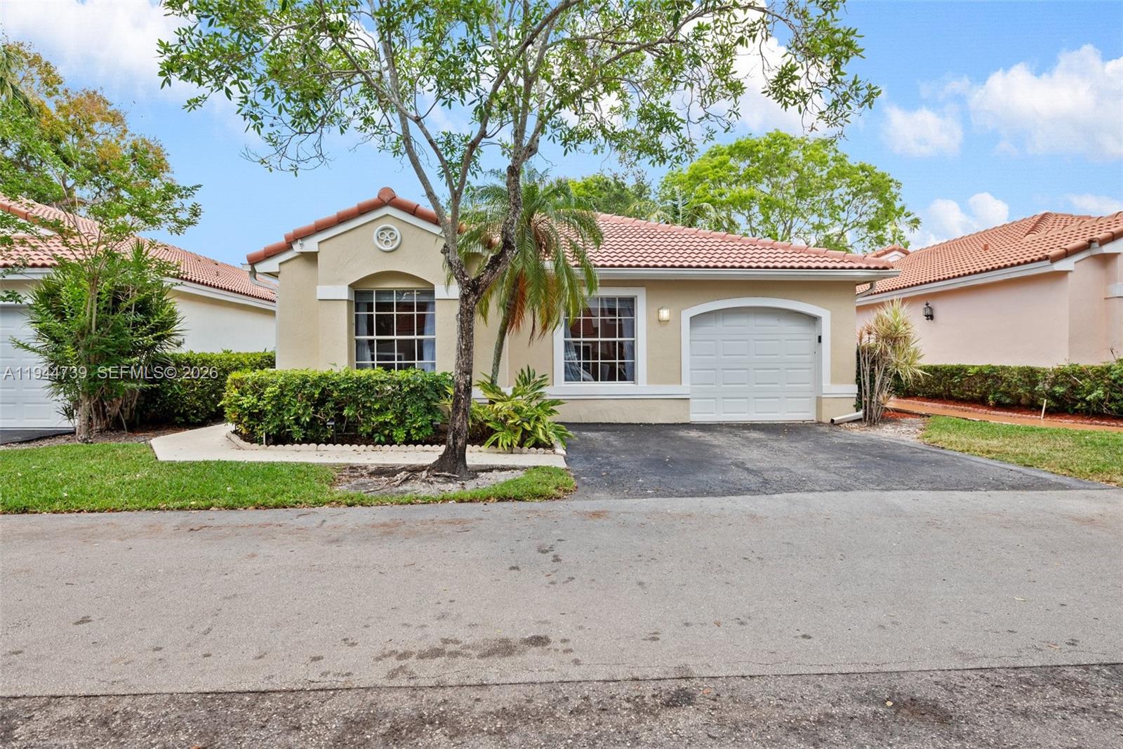 955 Azure Lane Weston, FL 33326 - Photo 1 of 34 a front view of a house with a yard and garage